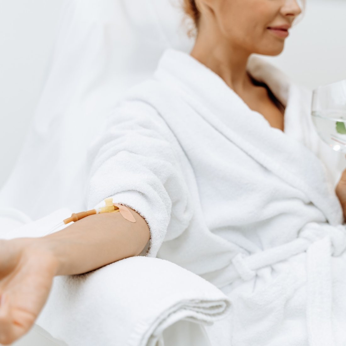 Close up of calm female patient sitting with tube and needle during IV infusion. Girl holding glass with lemon water and relaxing SSUCv3H4sIAAAAAAAACpyRy24DIQxF95X6DyPWGWkeTNr0V6IujMfJoBCIgElVRfn38hgi1t3hY/va1zze35qGCXAS2VfziFGIpVKr8xa8NDrgbrdxS3omW5O7HfddDWiW3lgJqoYCPC4arhSgXpWK+JmSzHnwqyMXp28IwdM5aGT4ksgrHnPclERKho6QYmxXMbeKxArK4v/qzI/v4gbOpPE3LVwZsaQIspFjLmWXH0/2WluDdZamcnU3CCoWjJXSzUqU+ly1Gb+ks5c2NKv2Nq7w2pwpY24gVDzxKWhS4Qs4F8rnwqtBGD7ZXKs52vhkYFNlc/iJGPbj8MkH/jn0/GPg3cT5VpB/b5FBJ61ThEKMFznX1mXcgOF4Gk6d6NpRIG/7nrAVALw9HAhxmmig/RQO//wDAAD//wMAiAg1bJgCAAA=